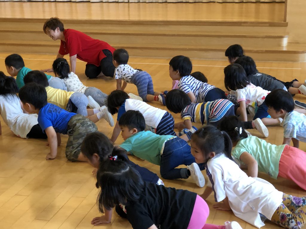 小さい園児さんがハイハイをしながら楽しく遊ぶ様子