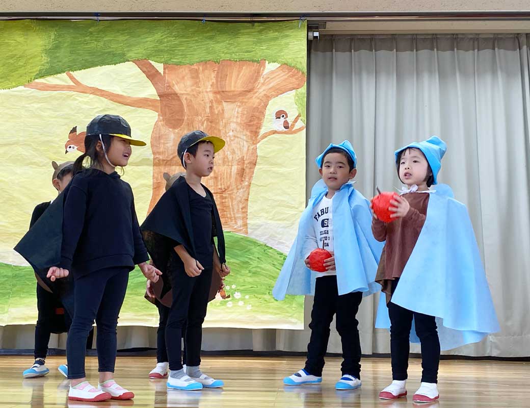 カラスのワーリーに扮したこども達がリンゴを渡している写真