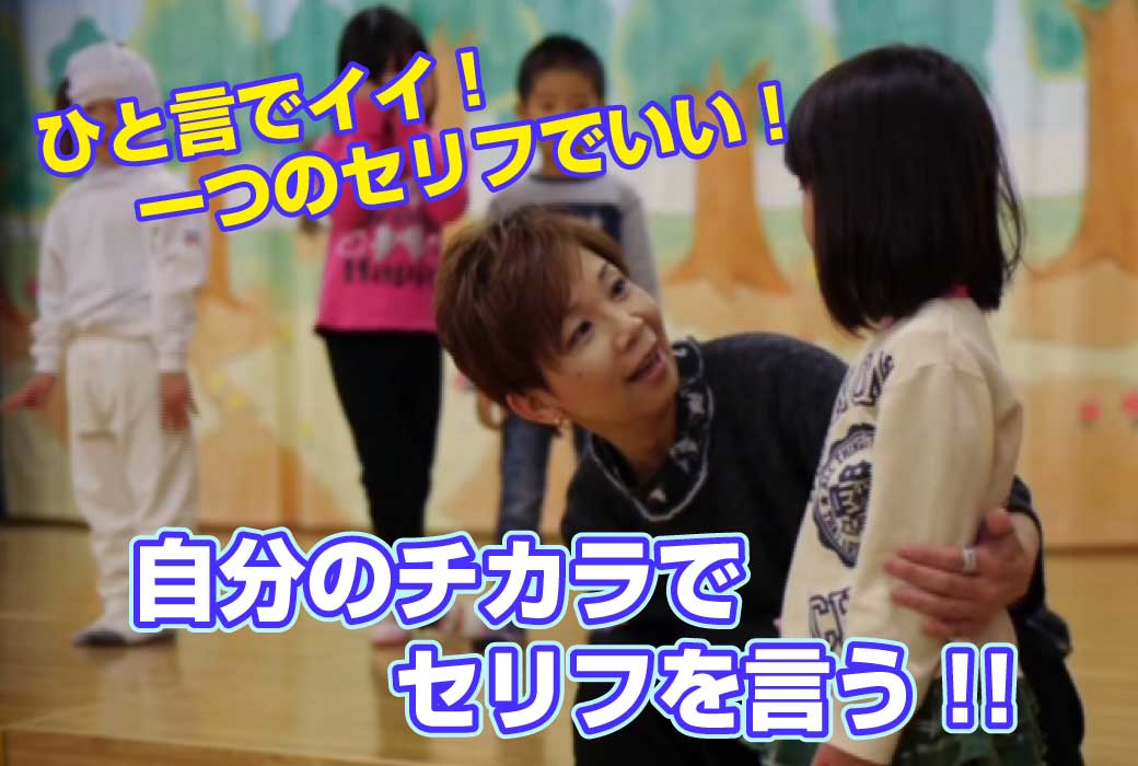 講師が劇の指導の場でこどもに優しく声をかけているところの写真